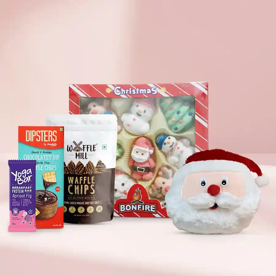 Unique Treasures Chocolate Gift Set featuring a Santa Claus face cushion, marshmallow Christmas box, Snackible Dipsters chocolate dip with waffle chips, Waffle Mill dark chocolate drizzle with sea salt, and a yoga protein bar.