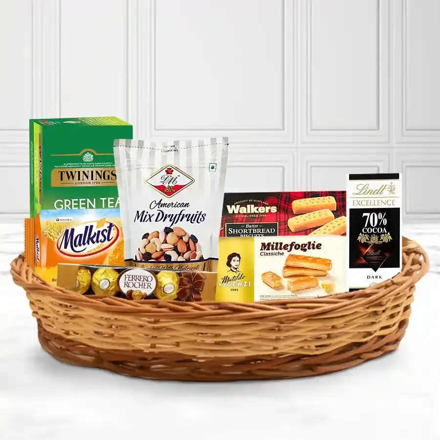 Magnificent X-Mas Goodies Basket filled with premium treats including Twinings tea, Ferrero Rocher, Lindt dark chocolate, mixed nuts, and crackers, presented in a reusable basket.