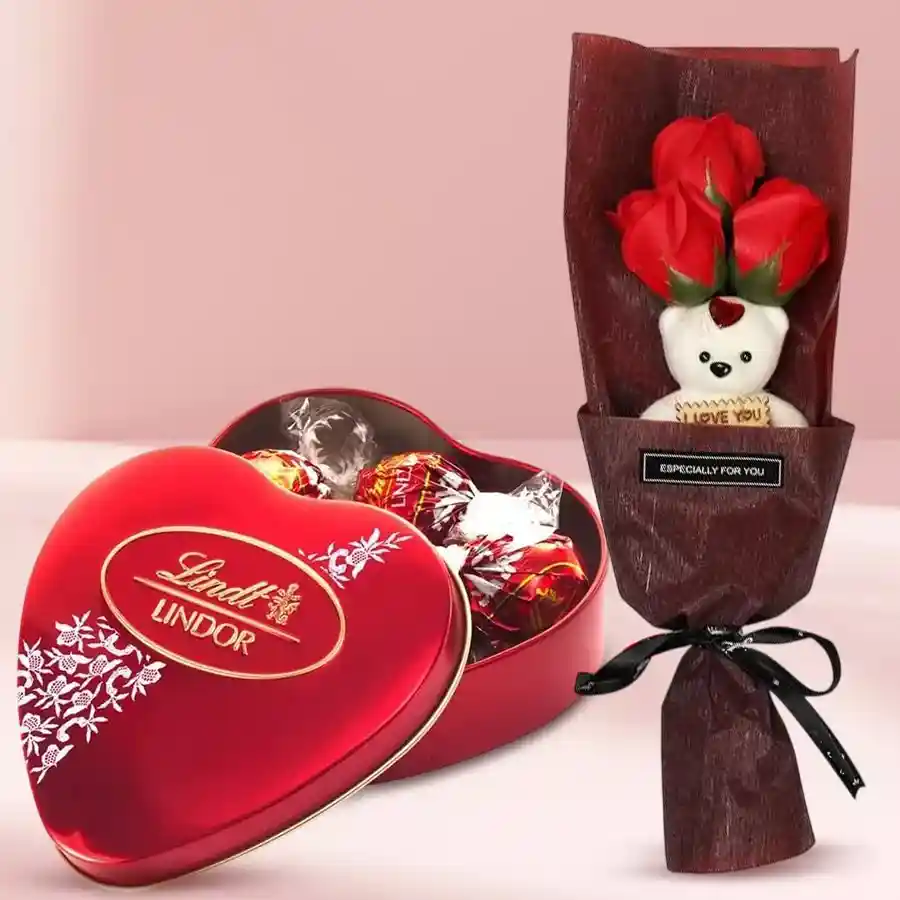 Bouquet of artificial red roses with a teddy bear and a box of Lindt Lindor chocolates