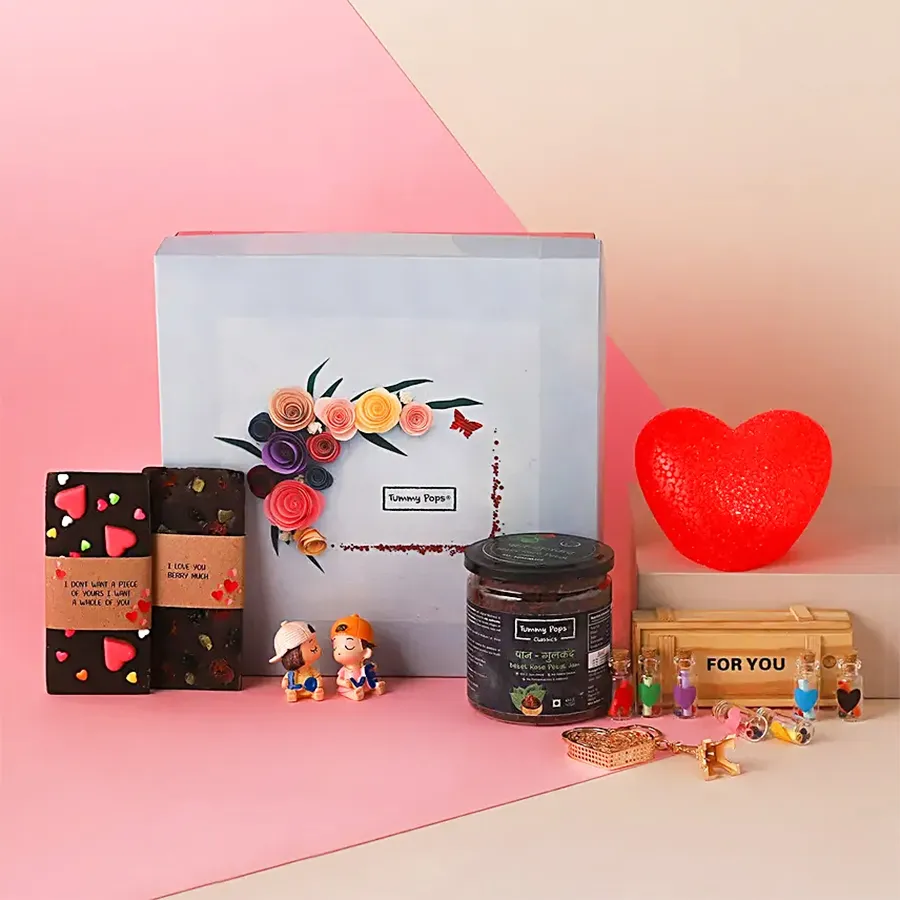 Luscious handmade chocolates with heart designs, an LED light heart, a miniature kissing couple, a message bottle, an Eiffel Tower keychain, a Paan Gulkand pack, a greetings card, all beautifully arranged in an elegant gift box.