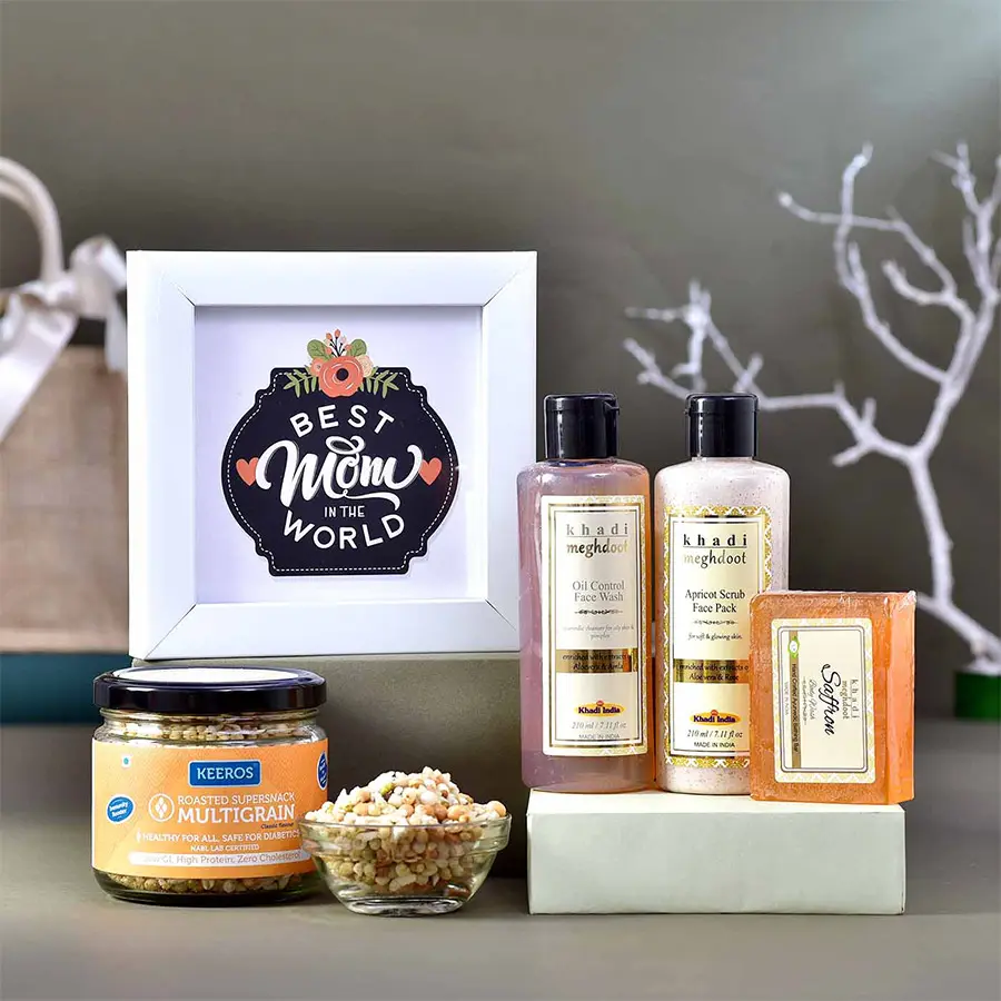 Mothers Glow Gift Hamper featuring a photo frame, Khadi Oil Control Facewash, Apricot Scrub Face Pack, Khadi Saffron Body Wash Soap, and Keeros Roasted Supersnack Multigrains