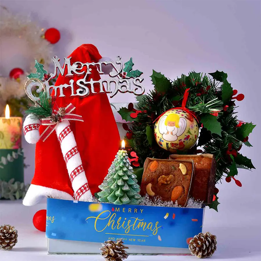 Christmas Carnival in a Tray featuring Carrot and Plum Cakes, decoration balls, a wreath, a joystick, a Christmas cap, festive candles, and tags, all beautifully arranged on a festive tray.
