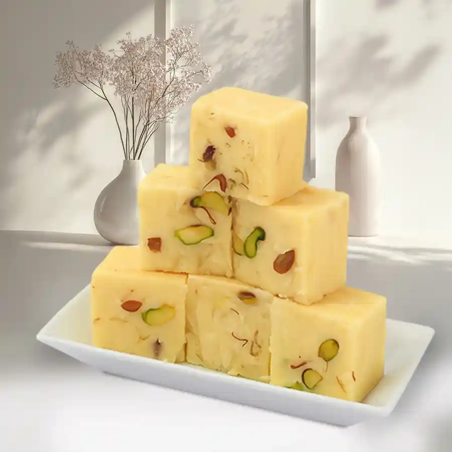 A box of Haldiram's Yummy Soan Papdi with a portion of the dessert displayed beside it, showcasing its flaky texture and rich color.