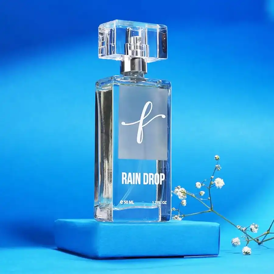 Rain Drop Perfume Fresh Rain Bliss bottle surrounded by raindrops and green leaves